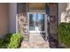 Covered entry features an iron security gate, stone tile walkway, and double door entrance at 5193 N Miller Ln, Las Vegas, NV 89149