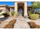 The covered entryway features decorative stone accents and an elegant iron gate with brick walkway at 5193 N Miller Ln, Las Vegas, NV 89149
