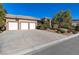 Single-story home with a tile roof, three-car garage, desert landscaping, and a spacious driveway at 5193 N Miller Ln, Las Vegas, NV 89149