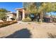 Desert landscaping highlights the stone accents and covered entry of this single-story home at 5193 N Miller Ln, Las Vegas, NV 89149