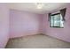 Bedroom with carpet floors, a window, and light purple walls at 5463 Waltham Ln, Las Vegas, NV 89122