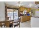 Eat-in kitchen featuring wood cabinets, white appliances, and sliding doors at 5463 Waltham Ln, Las Vegas, NV 89122