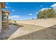 Large backyard featuring gravel landscaping, grass, and a tall privacy wall at 5790 Douglas Everett St, Las Vegas, NV 89120