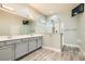 Elegant bathroom featuring double sinks, modern vanity, a glass-enclosed shower, and a wall-mounted TV for a luxurious feel at 5790 Douglas Everett St, Las Vegas, NV 89120