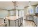 Bright, open kitchen with an island, granite countertops, stainless steel appliances, and modern light fixtures at 5790 Douglas Everett St, Las Vegas, NV 89120