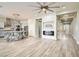 Open-concept living room with a fireplace, modern lighting, and a kitchen featuring a large center island with barstools at 5790 Douglas Everett St, Las Vegas, NV 89120