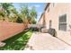 This backyard features a paved patio, artificial grass, and a neutral colored privacy fence at 6270 Dartington Hall St, Henderson, NV 89011