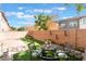 Relaxing backyard featuring artificial grass, a brick wall, outdoor decor, and a quaint seating area at 6270 Dartington Hall St, Henderson, NV 89011