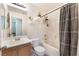 Bathroom with a shower-tub combo, wood vanity, and decorative shelves at 6270 Dartington Hall St, Henderson, NV 89011