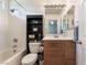 Bright bathroom features a shower-tub combo, black shelving, and a wood vanity at 6270 Dartington Hall St, Henderson, NV 89011
