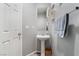 Compact powder room featuring a pedestal sink, light gray walls, and a modern mirror at 6270 Dartington Hall St, Henderson, NV 89011