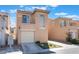 Two-story townhome with balcony, tidy landscaping, and individual garages with driveways at 6270 Dartington Hall St, Henderson, NV 89011