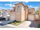This townhome features a two-story layout, personal garage, driveway, balcony, and tidy desert landscaping at 6270 Dartington Hall St, Henderson, NV 89011