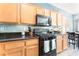 A well-appointed kitchen features oak cabinets, granite countertops, and stainless steel appliances at 6270 Dartington Hall St, Henderson, NV 89011