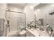 Bright bathroom features a glass shower, white tile, sink, and vanity at 6280 Lamont Hills Ave, Las Vegas, NV 89139