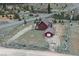 Aerial view of a red cabin with a garage, surrounded by a wooden fence and natural landscape at 660 E Aspen Meadow Dr, Mammoth Creek, UT 84735