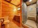 Rustic bathroom featuring wood paneled walls, stone tiled shower, and granite countertops at 660 E Aspen Meadow Dr, Mammoth Creek, UT 84735
