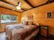 Bedroom with wood-paneled walls, ceiling fan, and large window with view at 660 E Aspen Meadow Dr, Mammoth Creek, UT 84735