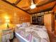 Bedroom with wood-paneled walls, ceiling fan, and walk-in closet at 660 E Aspen Meadow Dr, Mammoth Creek, UT 84735