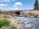 Picturesque creek flowing under a wooden bridge amidst a natural and rocky landscape at 660 E Aspen Meadow Dr, Mammoth Creek, UT 84735