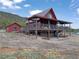 Charming cabin with a large deck and a separate garage, nestled in a mountainous landscape at 660 E Aspen Meadow Dr, Mammoth Creek, UT 84735