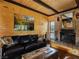 Inviting living room featuring a brick fireplace and comfortable leather seating, accented by wood paneling at 660 E Aspen Meadow Dr, Mammoth Creek, UT 84735
