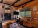 Comfortable living area featuring a brick fireplace, leather seating, and wood paneled walls at 660 E Aspen Meadow Dr, Mammoth Creek, UT 84735