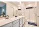 An immaculate bathroom features dual sinks, a large mirror, and a glass-enclosed shower at 759 Praire Plume St, Henderson, NV 89011