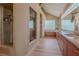 Spacious bathroom with wood cabinets, granite counters, a walk-in shower and glass block window at 7969 Bermuda Dunes Ave, Las Vegas, NV 89113