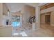 Open-concept living area with soaring ceilings, tiled floors, and staircase at 7969 Bermuda Dunes Ave, Las Vegas, NV 89113