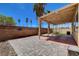 Backyard with paver patio, covered living space with light and palm trees, and block perimeter wall at 8039 Baldy Mountain Ave, Las Vegas, NV 89131