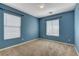 Sunlit blue bedroom with carpet, two windows, and neutral trim at 8039 Baldy Mountain Ave, Las Vegas, NV 89131