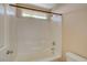 Updated white tiled bathtub and shower combination with neutral walls and window at 8039 Baldy Mountain Ave, Las Vegas, NV 89131