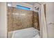 Corner bathtub features stylish tile surround and shower with curtain and window at 8222 Sorrel St, Las Vegas, NV 89139