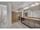 Bathroom with granite counters, and sinks, walk in shower with marble surround and tile floor at 8222 Sorrel St, Las Vegas, NV 89139