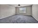 Spacious bedroom with plush gray carpet, ceiling fan, and window with white shutters at 8222 Sorrel St, Las Vegas, NV 89139