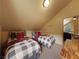 Bedroom featuring two wooden bed frames, plaid blankets, and a view of the upstairs living room at 855 E Ponderosa Rd, Mammoth Creek, UT 84735