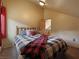 Bedroom featuring a wooden bed frame, a plaid blanket, and a window with red curtains at 855 E Ponderosa Rd, Mammoth Creek, UT 84735