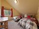 Bedroom featuring two wooden bed frames, plaid blankets, and a window with red curtains at 855 E Ponderosa Rd, Mammoth Creek, UT 84735