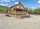 Beautiful two-story log home with a welcoming front porch and natural surroundings at 855 E Ponderosa Rd, Mammoth Creek, UT 84735
