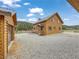 Charming log cabin home with a metal roof, mature trees, and gravel driveway at 855 E Ponderosa Rd, Mammoth Creek, UT 84735