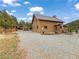 Charming log cabin home with a gravel driveway and detached garage at 855 E Ponderosa Rd, Mammoth Creek, UT 84735