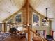 Living room with a high ceiling, wood paneling, many windows, and a stone fireplace at 855 E Ponderosa Rd, Mammoth Creek, UT 84735