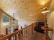 Upstairs living room with log railing, wood paneling, and a view of the downstairs area at 855 E Ponderosa Rd, Mammoth Creek, UT 84735