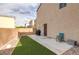 Backyard featuring a concrete patio, artificial turf, and a low brick perimeter wall at 9100 Balcony Trellis Ave, Las Vegas, NV 89149