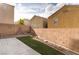 Backyard featuring a concrete patio, artificial turf, and a low brick perimeter wall at 9100 Balcony Trellis Ave, Las Vegas, NV 89149