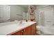 Clean bathroom with a shower-tub combo, framed mirror, wood cabinets, and decorative accents at 9100 Balcony Trellis Ave, Las Vegas, NV 89149