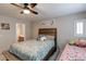 Comfortable bedroom featuring a ceiling fan, plush bedding and decor and an adjacent bathroom at 9100 Balcony Trellis Ave, Las Vegas, NV 89149