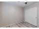 Simple bedroom features a ceiling fan, closet with sliding doors, and light hardwood floors at 9100 Balcony Trellis Ave, Las Vegas, NV 89149