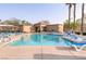 Inviting community pool surrounded by lounge chairs and palm trees for relaxation at 9100 Balcony Trellis Ave, Las Vegas, NV 89149